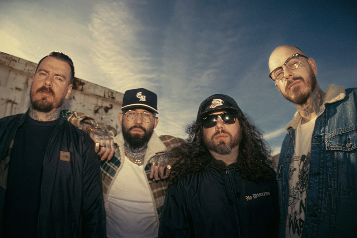 Promotional portrait of Australian hardcore band Deez Nuts posing outdoors under a bright blue sky.